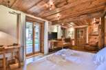 Experience rustic charm in this stunning bedroom featuring exposed wooden beams and a cozy ambiance.