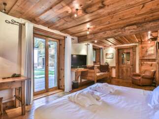 Experience rustic charm in this stunning bedroom featuring exposed wooden beams and a cozy ambiance.