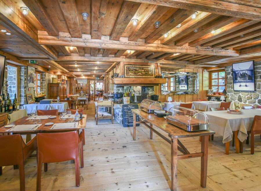 Step into the rustic charm of this exquisite restaurant, featuring exposed wooden beams and a cozy fireplace.