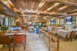 Step into the rustic charm of this exquisite restaurant, featuring exposed wooden beams and a cozy fireplace.