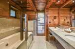 Experience luxury in this stunning bathroom featuring a beautiful wooden ceiling and walls, creating a warm and inviting atmosphere.