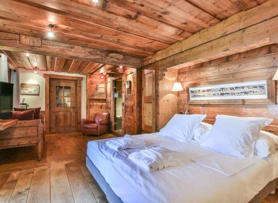 Experience rustic charm in this stunning bedroom featuring exquisite wooden paneling and a cozy ambiance.