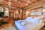 Experience rustic charm in this stunning bedroom featuring exquisite wooden paneling and a cozy ambiance.
