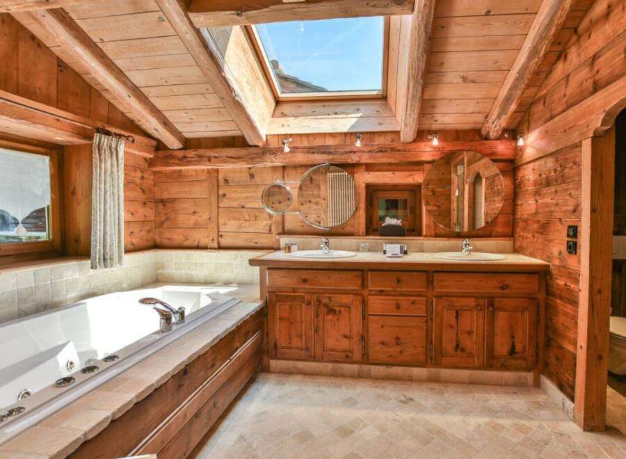 Step into luxury with this stunning bathroom featuring a rustic wooden design and a skylight that floods the space with natural light.