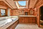 Step into luxury with this stunning bathroom featuring a rustic wooden design and a skylight that floods the space with natural light.