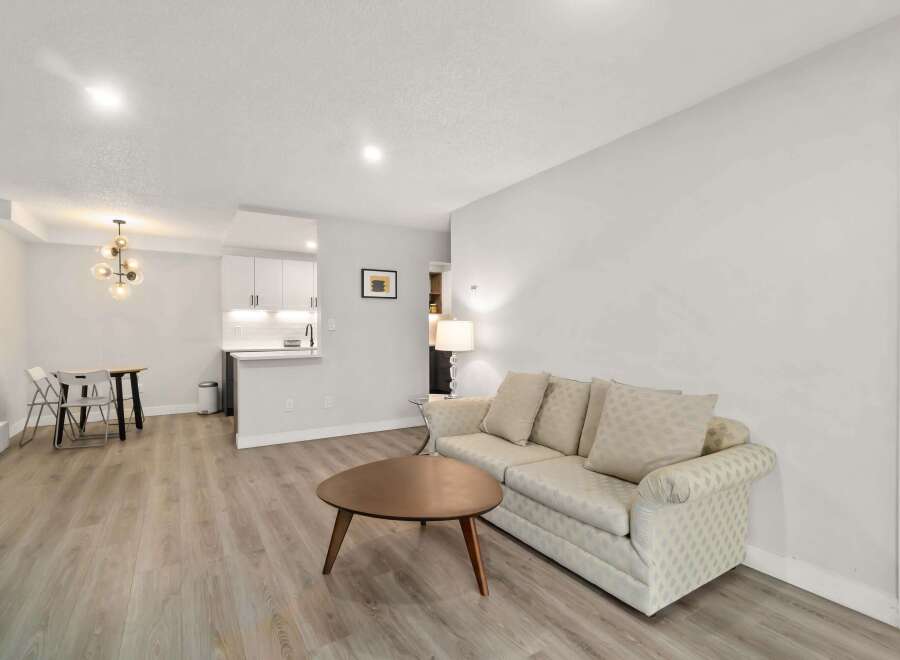 This stunning property boasts a modern living space with a cozy sofa and a stylish coffee table, perfect for relaxation.