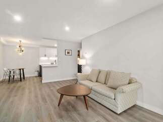 This stunning property boasts a modern living space with a cozy sofa and a stylish coffee table, perfect for relaxation.