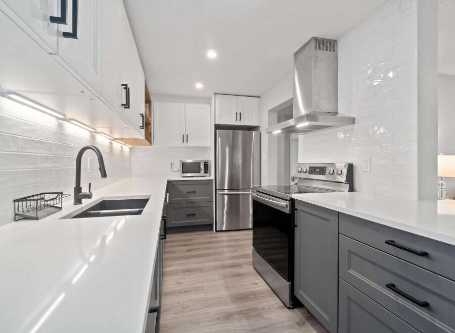 Step into this stunning kitchen, featuring sleek white cabinetry and modern gray accents.