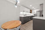 This modern kitchen boasts a sleek design with white cabinetry and contrasting gray lower cabinets.