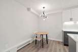 This charming dining area features a modern light fixture and a round wooden table, perfect for intimate meals.