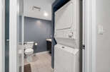 Step into this well-maintained bathroom featuring a convenient stacked washer and dryer, perfect for modern living.