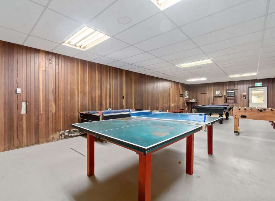 This recreational space features a variety of entertainment options, including a ping pong table, pool table, and foosball table.