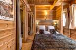 Experience the warmth and charm of this cozy bedroom, featuring stunning wood paneling and a luxurious faux fur blanket.