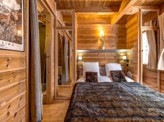 Experience the warmth and charm of this cozy bedroom, featuring stunning wood paneling and a luxurious faux fur blanket.