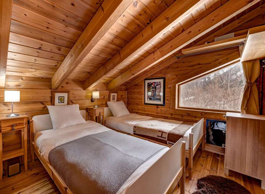 This cozy bedroom features a warm, inviting atmosphere with its wooden walls and ceiling.