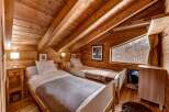 This cozy bedroom features a warm, inviting atmosphere with its wooden walls and ceiling.