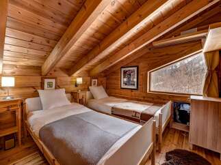 This cozy bedroom features a warm, inviting atmosphere with its wooden walls and ceiling.