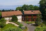 This stunning property boasts a modern design with a beautiful tile roof and a serene setting.