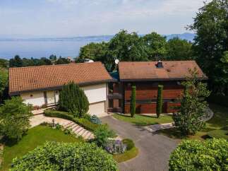 This stunning property boasts a modern design with a beautiful tile roof and a serene setting.