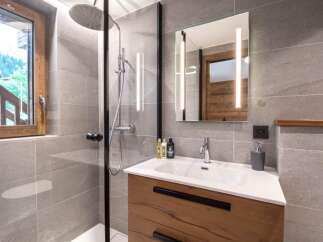 This modern bathroom features a sleek design with a walk-in shower and a stylish vanity.