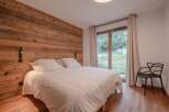 This cozy bedroom features a stunning wooden accent wall, creating a warm and inviting atmosphere.
