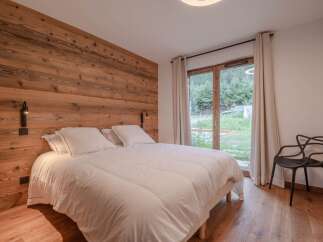 This cozy bedroom features a stunning wooden accent wall, creating a warm and inviting atmosphere.
