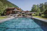 Experience luxury living in this stunning property featuring a beautiful pool and a charming wooden house.
