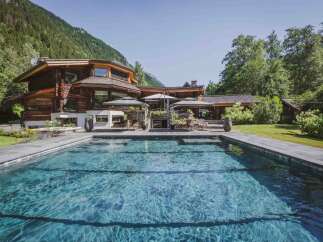 Experience luxury living in this stunning property featuring a beautiful pool and a charming wooden house.