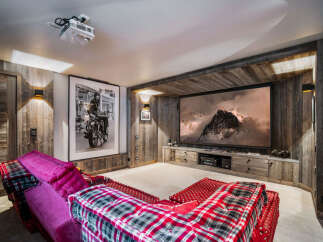Experience luxury living in this stunning home theater! Featuring a large screen, comfortable seating, and rustic wood accents, this space is perfect for movie nights.