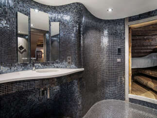 This unique bathroom showcases a stunning mosaic tile design, creating a luxurious and modern aesthetic.