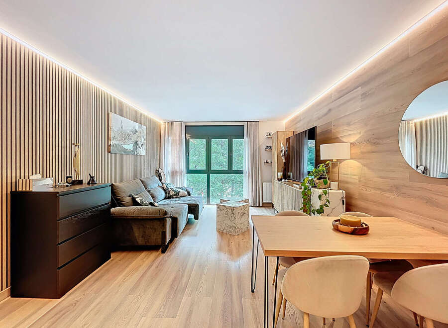 Discover modern living in this stylish apartment! Featuring a beautifully designed living room with wood paneling, a cozy sofa, and a sleek entertainment unit.