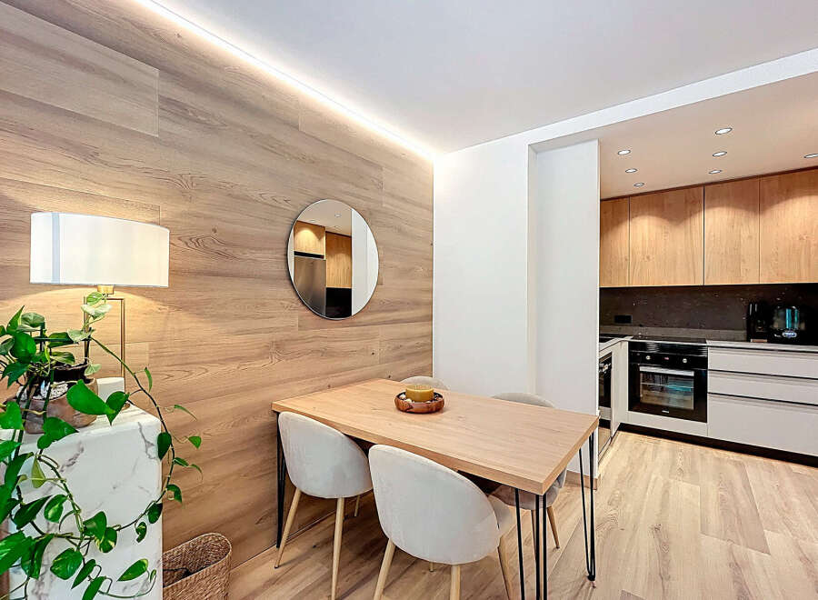 This modern apartment features a stylish dining area with a wooden table and chairs, perfect for enjoying meals.