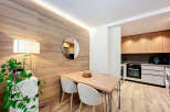 This modern apartment features a stylish dining area with a wooden table and chairs, perfect for enjoying meals.
