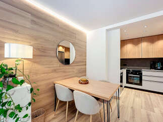 This modern apartment features a stylish dining area with a wooden table and chairs, perfect for enjoying meals.
