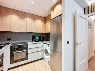 Discover modern living in this stylish kitchen! Featuring sleek cabinetry, stainless steel appliances, and a convenient washer and dryer, this space is designed for both functionality and elegance.