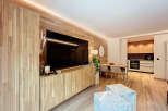 Experience modern living in this stylish property, featuring a sleek entertainment center with a large TV and custom cabinetry.