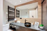 This modern bathroom boasts a sleek design with a dark marble countertop and a stylish black sink.