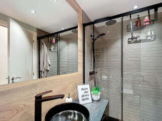 Step into a modern bathroom oasis! This stylish space features a sleek black faucet, a contemporary sink, and a luxurious shower with a rain showerhead.