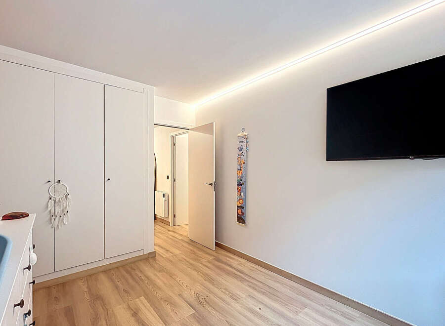 This bright and airy bedroom features a large built-in wardrobe, providing ample storage space.