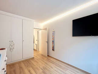 This bright and airy bedroom features a large built-in wardrobe, providing ample storage space.