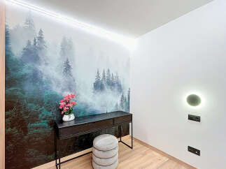This stunning property features a unique forest-themed accent wall, creating a serene and inviting atmosphere.