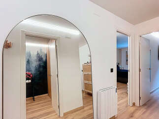 Step into this stylish entryway, featuring a stunning arched mirror that amplifies natural light and creates a sense of spaciousness.
