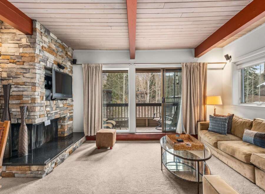 Experience the warmth of this stunning living room, featuring a beautiful stone fireplace and a cozy seating area.