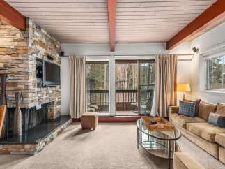 Experience the warmth of this stunning living room, featuring a beautiful stone fireplace and a cozy seating area.