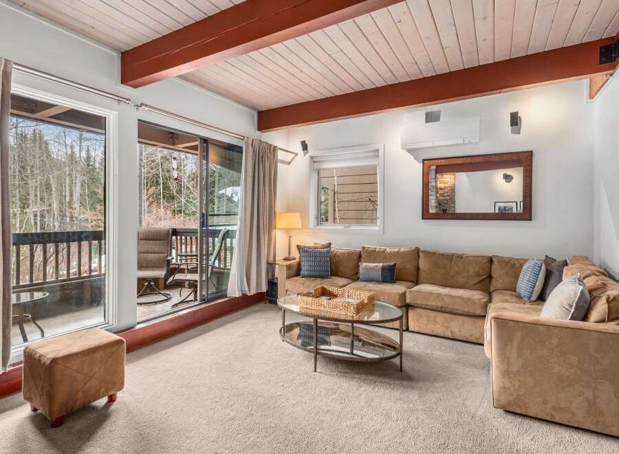 Step into this inviting living space, featuring a cozy sectional sofa and a stunning view of the surrounding nature.