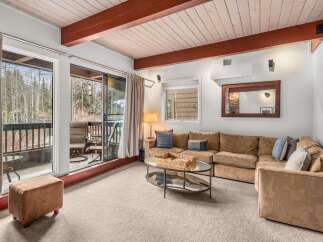 Step into this inviting living space, featuring a cozy sectional sofa and a stunning view of the surrounding nature.