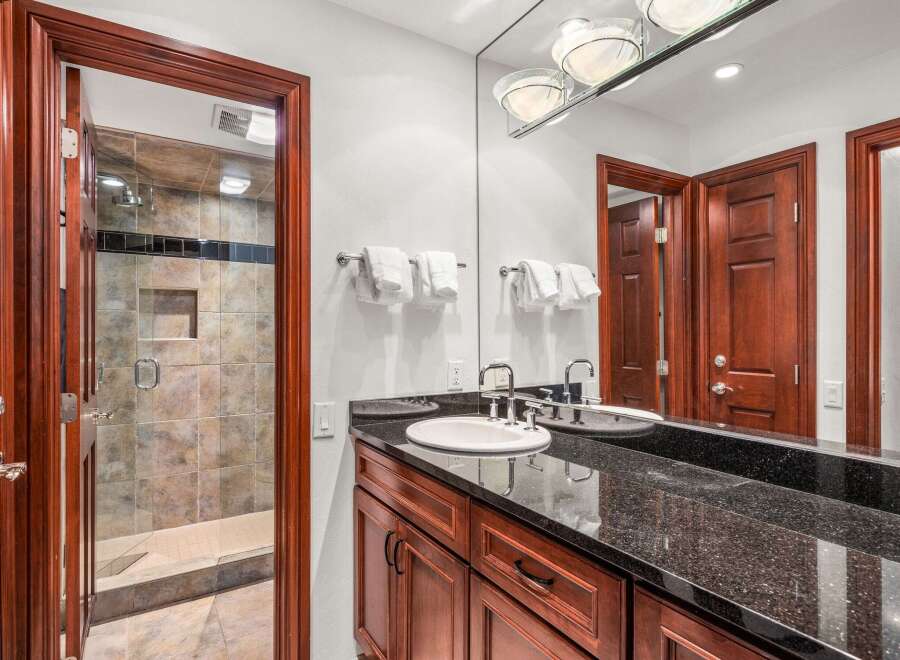 This stunning bathroom features a sleek granite countertop and a modern sink, perfect for a luxurious experience.