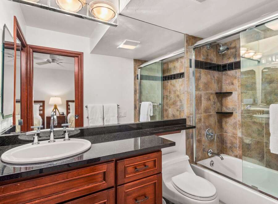 This luxurious bathroom boasts a sleek design with a modern vanity and a spacious shower.