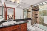 This luxurious bathroom boasts a sleek design with a modern vanity and a spacious shower.