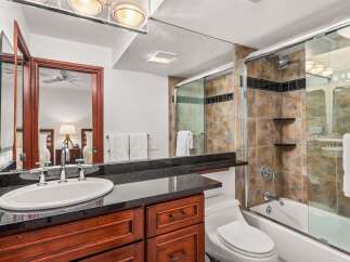 This luxurious bathroom boasts a sleek design with a modern vanity and a spacious shower.